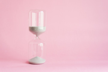 hourglass on pink background
