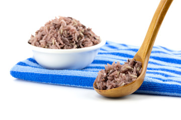 Brown rice in a wooden spoon with white background isolated with copy space