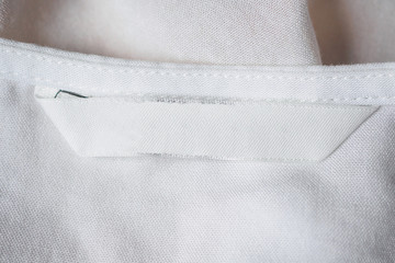 White blank laundry care clothes label on cotton shirt