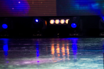 colorful stage lights with their reflections on a stage