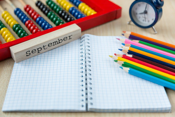 colorful abacus , pencils, clock, chalkboard on the wooden background. Education, back to school concept  