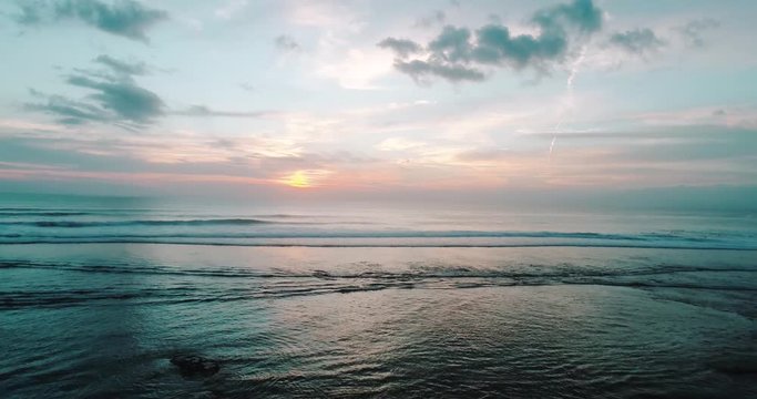 Aerial drone view of sunset on the ocean coast, sea, beach, sky, clouds. Sunset on the island of Bali, Indonesia