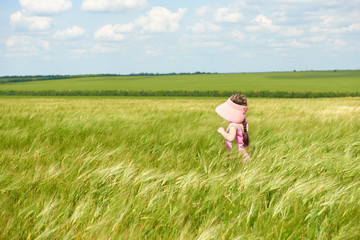 child walking through the wheat field, bright sun, beautiful summer landscape