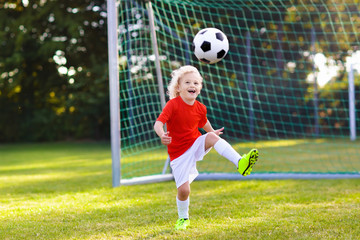 Kids play football. Child at soccer field. © famveldman
