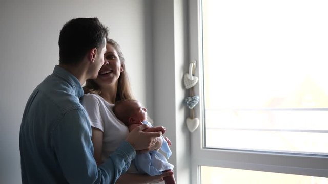 New parents young couple mother and father learn to take care about newborn baby at home