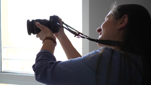 Professional photographer entrepreneur woman takes pictures on family photosession at home