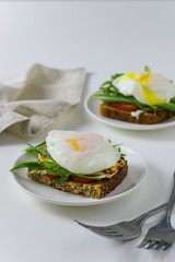 A healthy breakfast (egg poached, whole grain bread, tomato and arugula).