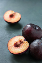 Naklejka na ściany i meble Ripe plums close-up on a dark table