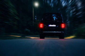 Van rides on road very fast around forest at night. Vip and luxury van go fast