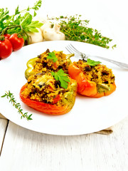 Pepper stuffed with mushrooms and couscous in white plate on board