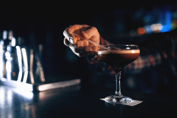 elegant glass with espresso martini cocktail on blue background;