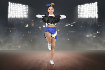 Young asian cheerleader in action with pom poms