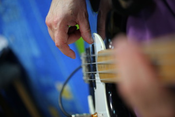 hands of a man playing an electric guitar