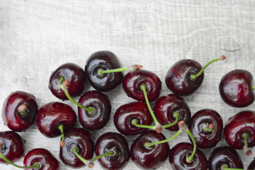 Spelled cherries on the white wooden background