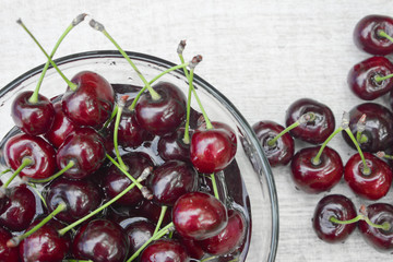 Spelled cherries on the white wooden background