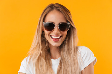 Portrait of a cheerful young blonde girl in sunglasses