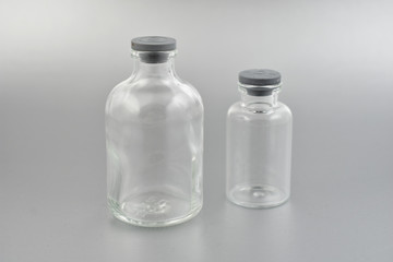 Glass laboratory vials stock images. Glass phial images. Laboratory vial on a silver background. Laboratory vials with a plastic stopper