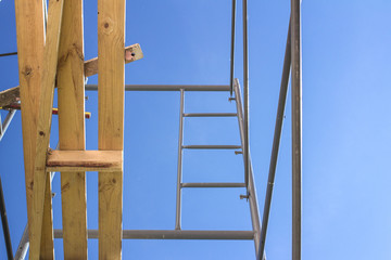 Silhouette of construction workers on scaffold working under a blue sky