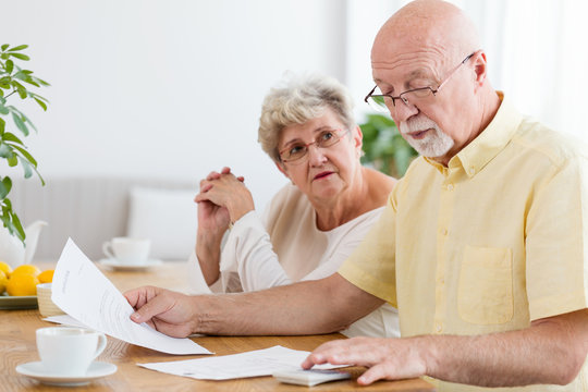 Elderly couple calculating costs of household. Senior people with low pension