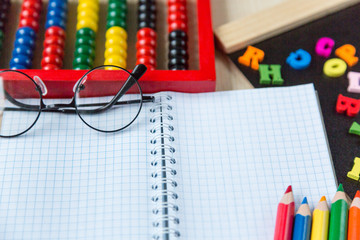 colorful abacus , pencils, clock, chalkboard on the wooden background. Education, back to school...