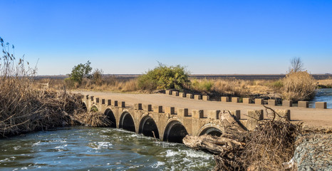 Fototapeta premium South African landscape of an old concrete low water bridge over the Klip River in Gauteng image with copy space in landscape format