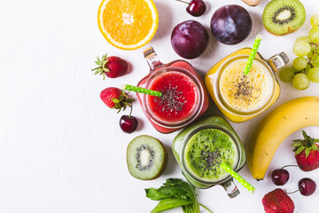 Selection of multicolored fruit smoothies  in glass jars.