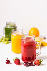 Red, yellow and green smoothie in a glass jar and ingredients