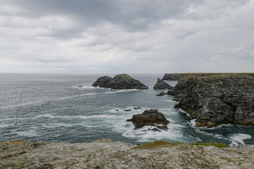 Fototapeta na wymiar Typical brittany rocky coastline with grey cloudy sky and immensity of atlantic ocean, Belle Ile melancholic landscape