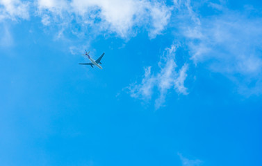 Fototapeta na wymiar Airplane on blue sky and white clouds. Commercial airline flying on blue sky. Travel flight for vacation. Aviation transport.