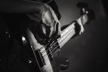  Handen van elektrische basgitarist, livemuziek © evannovostro