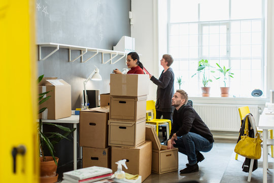 People handling boxes in office