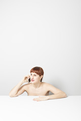 conceptual portrait of young beautiful woman with red hair: she is talking on the phone with a friend and she is surprised