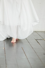 Fototapeta na wymiar the bride walks barefoot on the wooden floor