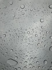 Rain drops on window glasses surface with cloudy background Natural Pattern of raindrops isolated on cloudy background 