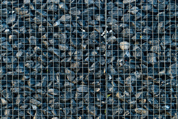 Fototapeta premium Background with crushed stones, elements, gravel in a metal grid