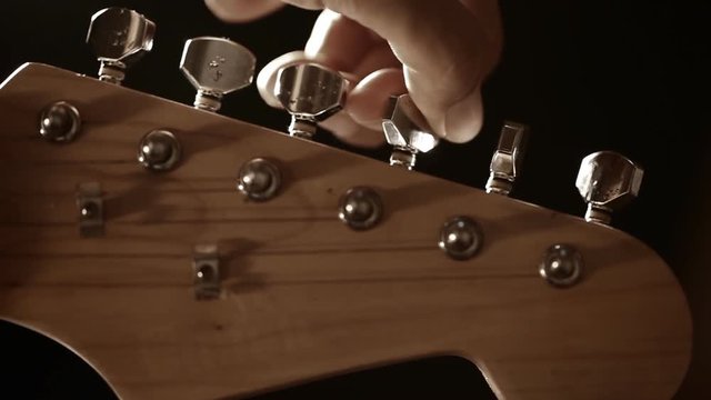 Guitarist tuning electric guitar