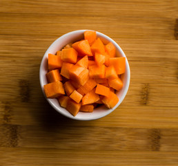 Diced carrots on wooden chopping board