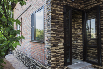 Facing the facade of a private house with a decorative stone. Content construction.