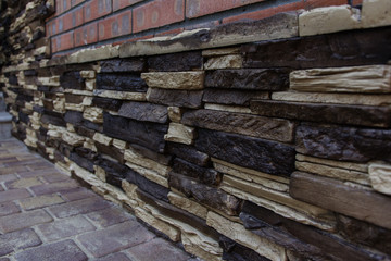 Facing the foundation of a brick house with a decorative stone. Content construction.