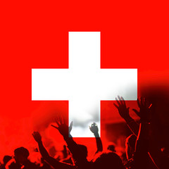 football fans supporting Switzerland - crowd in stadium with raised hands against Switzerland flag...