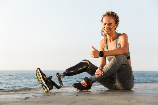 Smiling disabled athlete woman with prosthetic leg - Powered by Adobe