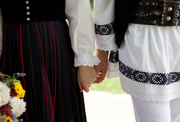 bride wearing a traditional hungarian wedding dress and groom in a traditional romanian costume -...