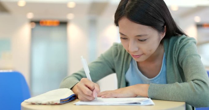 Student writing on her note at school