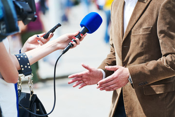 Fototapeta media reporter with microphone making journalist interview for news obraz
