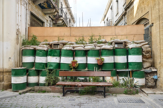 Dead zone at Nicosia. Barricades in Nicosia, Lefkosia, Cyprus. Blockhouse, checkpoint, sentry post. Painted barrels, plants, bench. Abandoned houses.