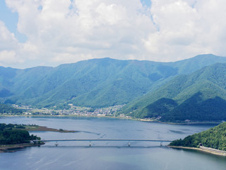 Scenery of Lake Kawaguchi, the biggest lake of Fuji five lakes, with an overwater bridge crossing the lake and mt Kurodake on the background, famous tourist destination in Japan