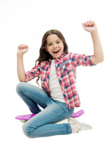 Obraz premium Time to ride. Kid girl excited sits penny board. Modern teen hobby. Girl happy face sit on penny board white background. Originally designed as girls skateboard. Learning how to ride penny board
