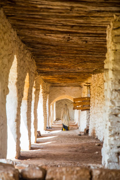 Woman walking down corridor with arches