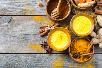 Obraz na płótnie Canvas Traditional indian drink turmeric curcuma golden milk with ingredients