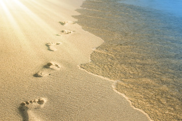 Fototapeta na wymiar beautiful footprints in the sand near the sea on nature background